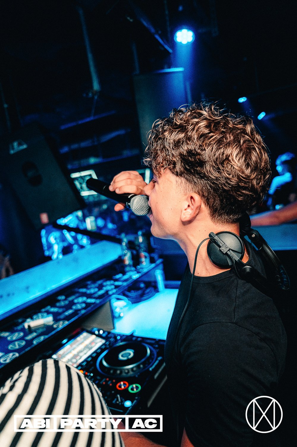 DJ Haemmer performt mit Mikrofon im Bühnenlicht
