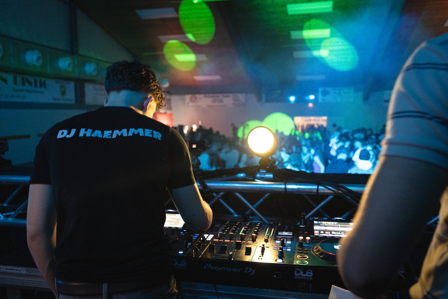DJ Haemmer im DJ-Haemmer-Shirt am Pult mit Blick auf die Menge