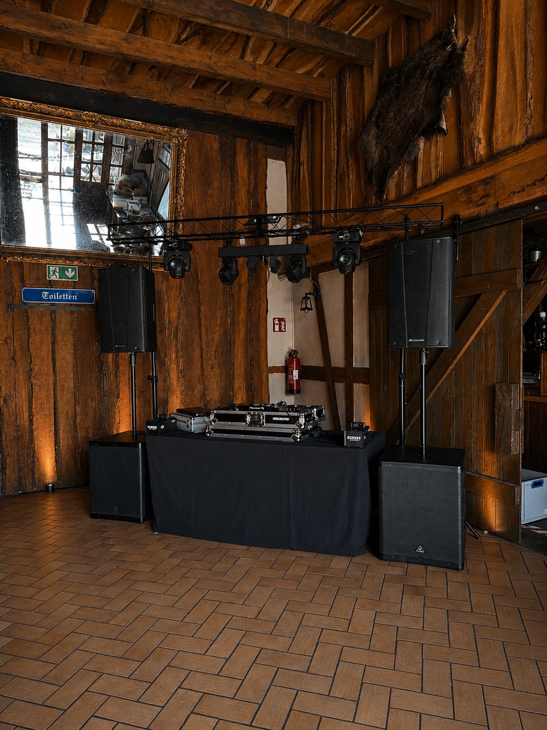 DJ-Aufbau mit Boxen und Lichttraverse in einem Fachwerkhaus für eine Hochzeitsfeier